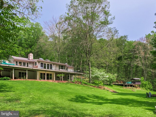 2762 Horseshoe Trl, Chester Springs, PA 19425 - back of property featuring a chimney, a lawn, and a forest view