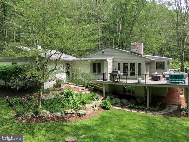 2762 Horseshoe Trl, Chester Springs, PA 19425 - back of property with a chimney, a wooden deck, a yard, and a forest view