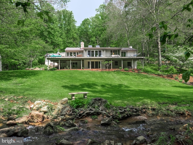 2762 Horseshoe Trl, Chester Springs, PA 19425 - back of house with a chimney, a forest view, a lawn, and a wooden deck