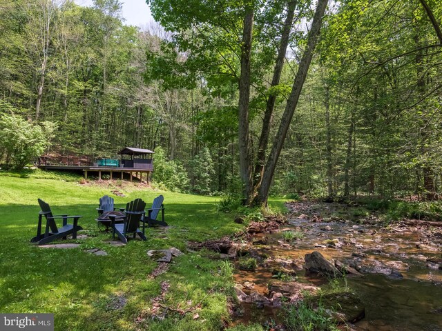 2762 Horseshoe Trl, Chester Springs, PA 19425 - view of green lawn with a forest view, a deck, and a fire pit