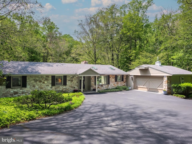2762 Horseshoe Trl, Chester Springs, PA 19425 - ranch-style home featuring stone siding, asphalt driveway, a garage, and a chimney