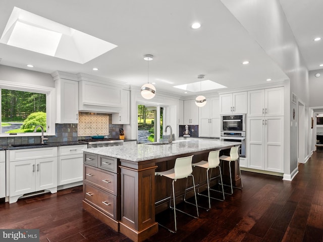 2762 Horseshoe Trl, Chester Springs, PA 19425 - kitchen with a skylight, dark wood finished floors, decorative backsplash, white cabinetry, and recessed lighting