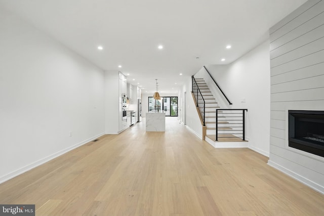 3802 T St NW, Washington, DC 20007 - unfurnished living room with stairway, recessed lighting, light wood finished floors, a large fireplace, and baseboards