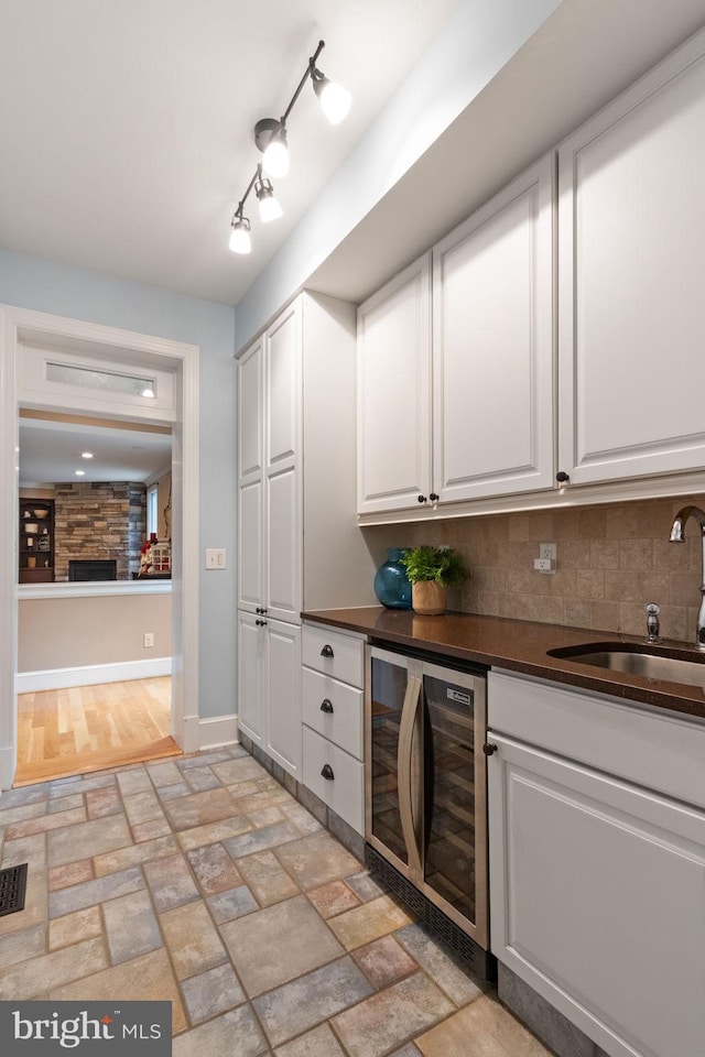 10108 Rockinghorse Ln, Spotsylvania, VA 22553 - bar area with beverage cooler, a sink, baseboards, tasteful backsplash, and a stone fireplace