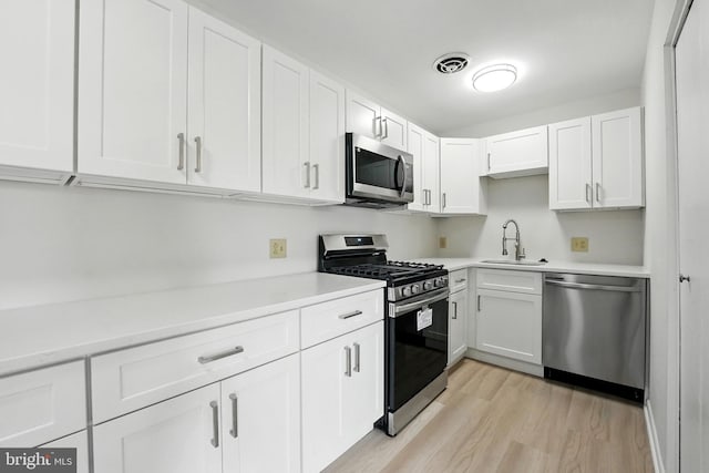 218 Locust St SE Unit 151, Vienna, VA 22180 - kitchen with stainless steel appliances, light wood-style floors, light countertops, and white cabinetry