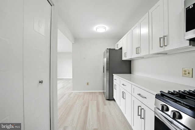 218 Locust St SE Unit 151, Vienna, VA 22180 - kitchen featuring white cabinets, appliances with stainless steel finishes, light countertops, and light wood-style floors