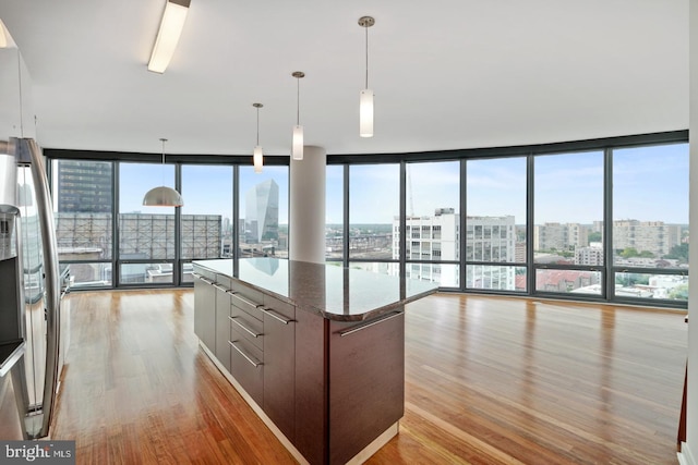 2101 Market St Unit 902, Philadelphia, PA 19103 - kitchen with a view of city, light wood-style flooring, a kitchen island, expansive windows, and stainless steel refrigerator with ice dispenser