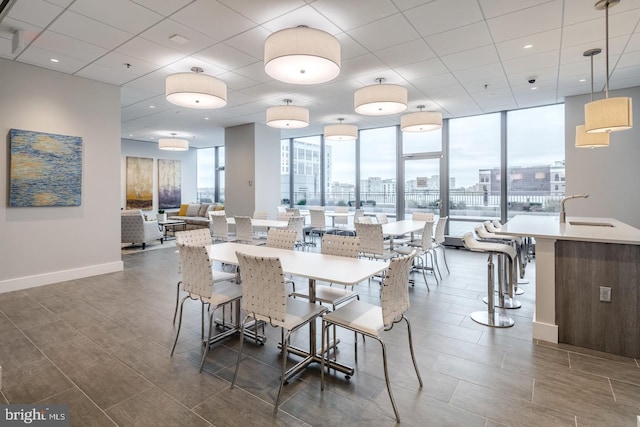 2101 Market St Unit 902, Philadelphia, PA 19103 - dining area with a city view, baseboards, a wall of windows, dark wood finished floors, and a paneled ceiling