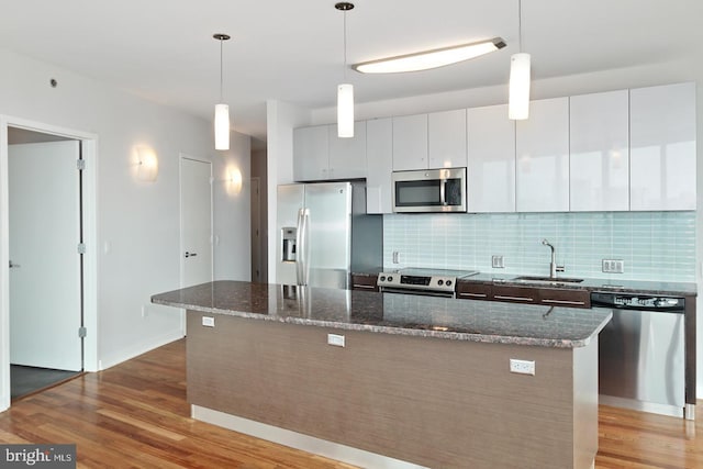 2101 Market St Unit 902, Philadelphia, PA 19103 - kitchen featuring stainless steel appliances, a sink, wood finished floors, and backsplash