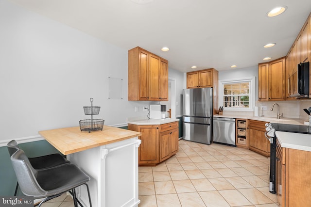 4301 Ivanhoe Pl, Alexandria, VA 22304 - kitchen featuring stainless steel appliances, a sink, light tile patterned floors, light countertops, and recessed lighting