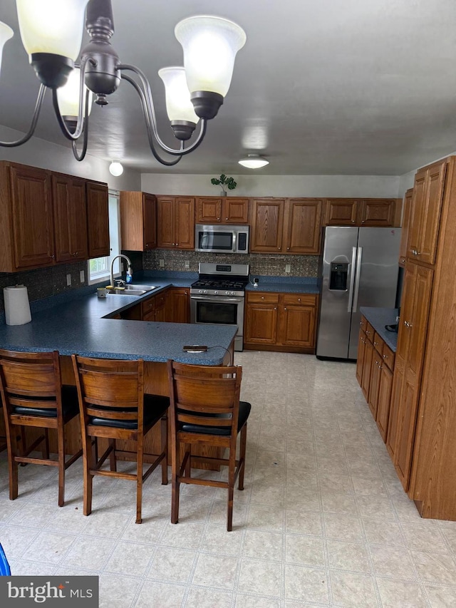3948 Laurel Run, Columbia, PA 17512 - kitchen with stainless steel appliances, a sink, a peninsula, dark countertops, and tasteful backsplash
