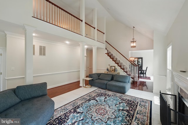 19885 Naples Lakes Ter, Ashburn, VA 20147 - living room with high vaulted ceiling, ornate columns, stairway, wood finished floors, and a chandelier