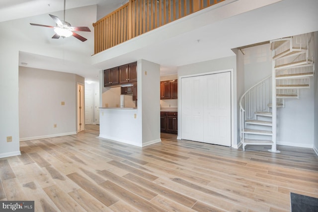 4100 Monument Ct Unit 302, Fairfax, VA 22033 - unfurnished living room featuring a high ceiling, ceiling fan, stairway, and light wood-type flooring
