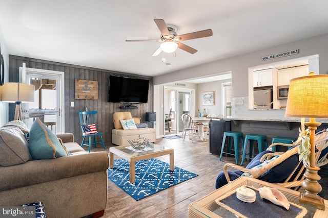 183 Jamestown Rd Unit 10, Ocean City, MD 21842 - living area with a ceiling fan, plenty of natural light, wood finished floors, and wood walls