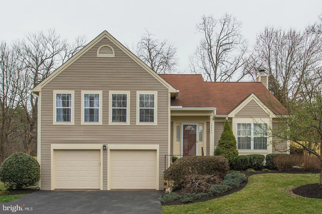 13504 Union Village Cir, Clifton, VA 20124 - view of front facade with asphalt driveway, a garage, a chimney, and a front lawn