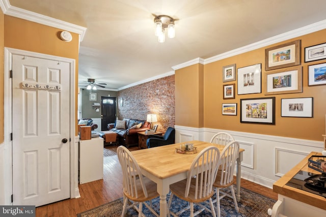 2326 E Boston St, Philadelphia, PA 19125 - dining space featuring wood finished floors, ornamental molding, ceiling fan, a wainscoted wall, and a decorative wall