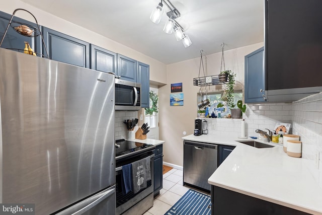 2326 E Boston St, Philadelphia, PA 19125 - kitchen featuring stainless steel appliances, a sink, decorative backsplash, light countertops, and blue cabinets