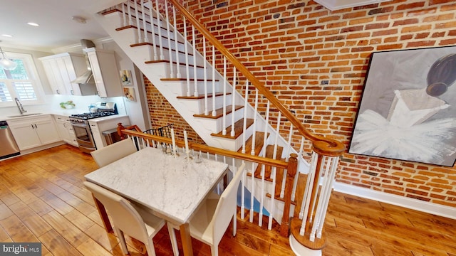 2714 Fait Ave, Baltimore, MD 21224 - dining room with brick wall, ornamental molding, light wood finished floors, stairs, and recessed lighting