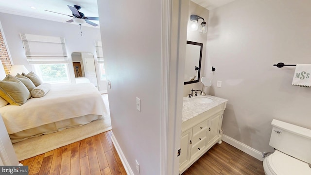 2714 Fait Ave, Baltimore, MD 21224 - bathroom featuring baseboards, ceiling fan, hardwood / wood-style flooring, vanity, and toilet