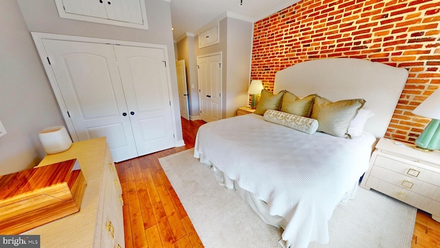 2714 Fait Ave, Baltimore, MD 21224 - bedroom with hardwood / wood-style floors, brick wall, a closet, crown molding, and an accent wall