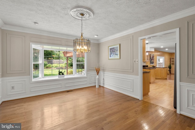 17220 Larosa Dr, Rockville, MD 20855 - unfurnished dining area with healthy amount of natural light, a decorative wall, light wood-type flooring, a chandelier, and a textured ceiling