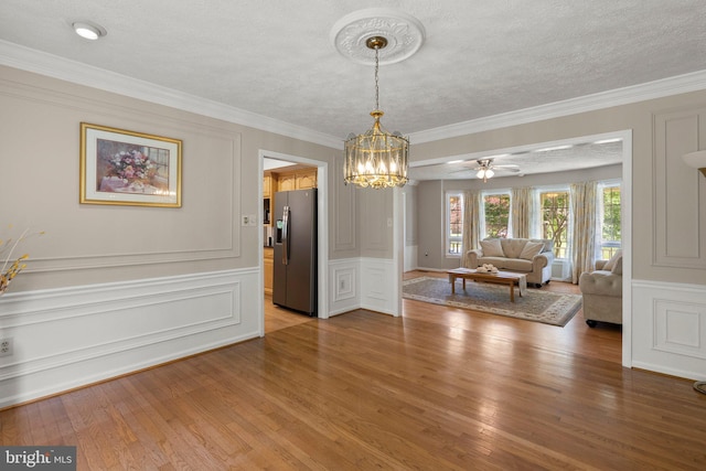 17220 Larosa Dr, Rockville, MD 20855 - dining area featuring light wood finished floors, a decorative wall, a chandelier, ornamental molding, and a wainscoted wall