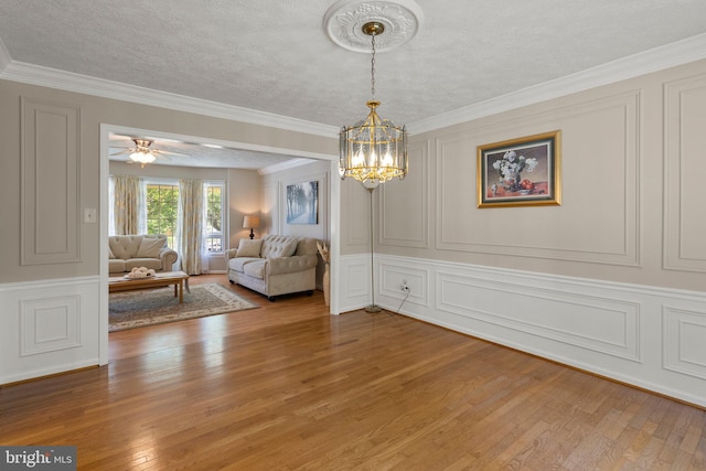 17220 Larosa Dr, Rockville, MD 20855 - living room featuring a decorative wall, light wood-type flooring, a chandelier, ornamental molding, and a textured ceiling
