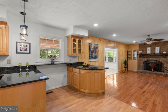 17220 Larosa Dr, Rockville, MD 20855 - kitchen with light wood finished floors, a peninsula, a ceiling fan, a textured ceiling, and glass insert cabinets