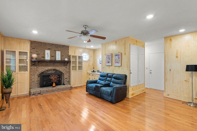 17220 Larosa Dr, Rockville, MD 20855 - living room featuring wood finished floors, ceiling fan, wood walls, a fireplace, and recessed lighting