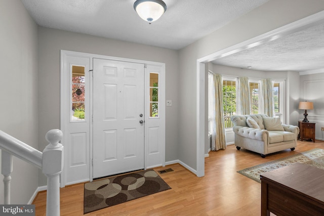 17220 Larosa Dr, Rockville, MD 20855 - entrance foyer with light wood-type flooring, a textured ceiling, and baseboards