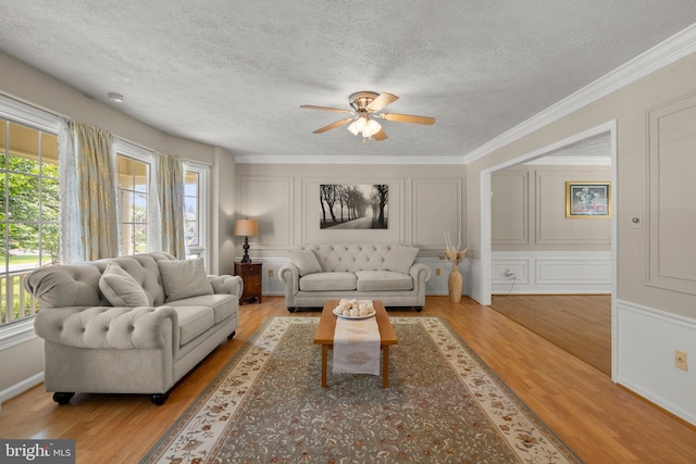 17220 Larosa Dr, Rockville, MD 20855 - living area featuring a decorative wall, plenty of natural light, wood finished floors, a ceiling fan, and a textured ceiling
