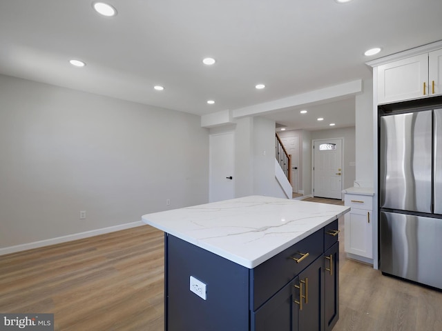 7907 Wallace Rd, Dundalk, MD 21222 - kitchen featuring freestanding refrigerator, light wood-style flooring, a kitchen island, white cabinets, and recessed lighting