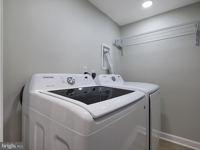 7907 Wallace Rd, Dundalk, MD 21222 - washroom with washing machine and clothes dryer, baseboards, and wood finished floors