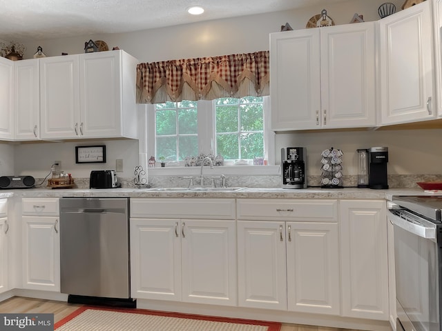 6165 Hawthorne Rd, La Plata, MD 20646 - kitchen with stainless steel appliances, a sink, white cabinets, and light wood-type flooring