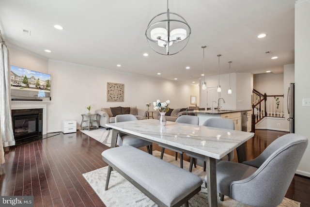 42533 Benfold Sq, Brambleton, VA 20148 - dining area with a glass covered fireplace, dark wood finished floors, stairway, and recessed lighting