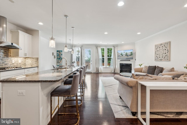 42533 Benfold Sq, Brambleton, VA 20148 - kitchen with wall chimney range hood, a sink, stainless steel gas cooktop, open floor plan, and an island with sink