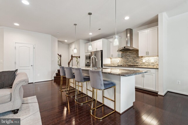 42533 Benfold Sq, Brambleton, VA 20148 - kitchen with wall chimney range hood, a kitchen breakfast bar, backsplash, white cabinetry, and stainless steel appliances