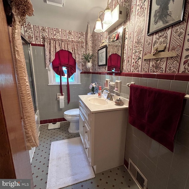 603 Jefferson Blvd, Reading, PA 19609 - full bath featuring tile walls, vanity, toilet, wainscoting, and enclosed tub / shower combo