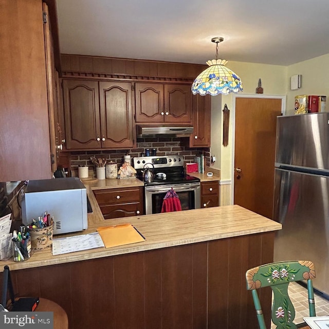 603 Jefferson Blvd, Reading, PA 19609 - kitchen featuring appliances with stainless steel finishes, light countertops, a peninsula, under cabinet range hood, and backsplash