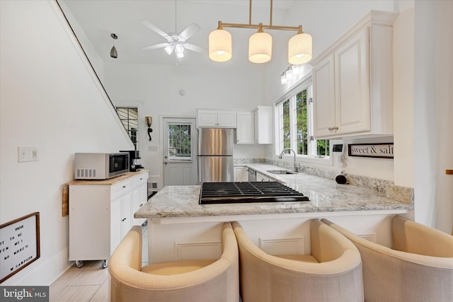 5804 Woodcrest Ave, Baltimore, MD 21215 - kitchen featuring stainless steel appliances, a sink, a peninsula, and white cabinets