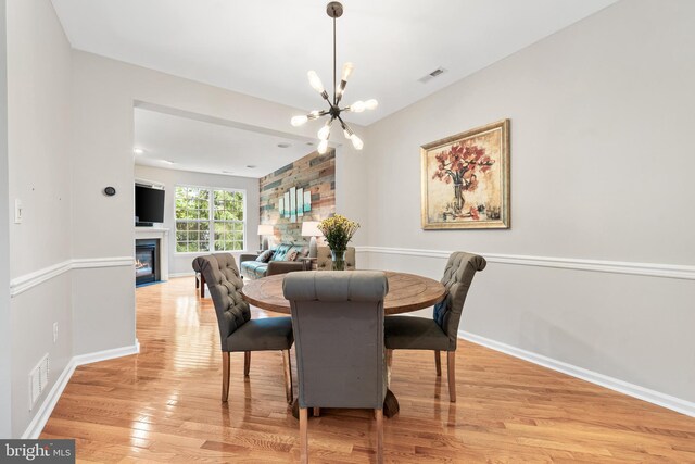 25 Kennedy Ct, Princeton, NJ 08540 - dining area with a chandelier, light wood finished floors, a glass covered fireplace, and baseboards