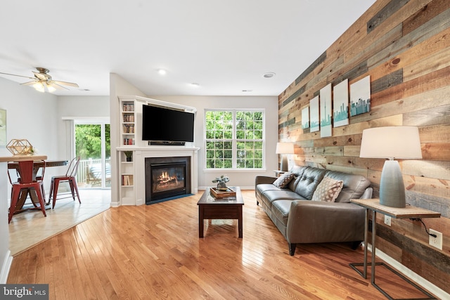 25 Kennedy Ct, Princeton, NJ 08540 - living area featuring plenty of natural light, ceiling fan, wood walls, light wood-style flooring, and a fireplace with flush hearth