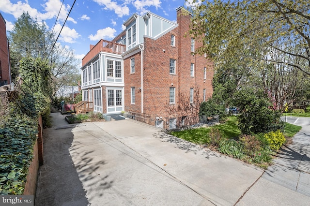 4700 Upton St NW Unit 3, Washington, DC 20016 - view of side of home with a balcony, brick siding, driveway, and a chimney