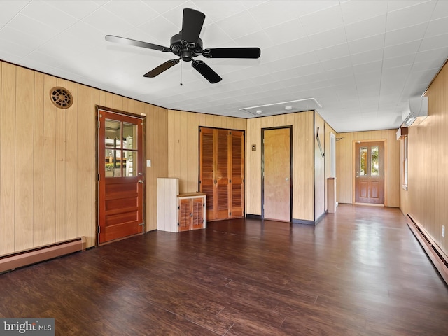 1229 7 Oaks Rd, Halethorpe, MD 21227 - unfurnished living room with baseboard heating, a wall unit AC, wood walls, wood finished floors, and ceiling fan