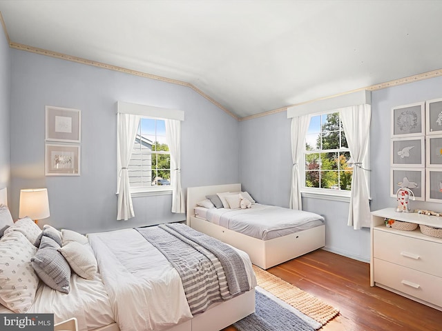 1229 7 Oaks Rd, Halethorpe, MD 21227 - bedroom with vaulted ceiling, multiple windows, wood finished floors, ornamental molding, and baseboards