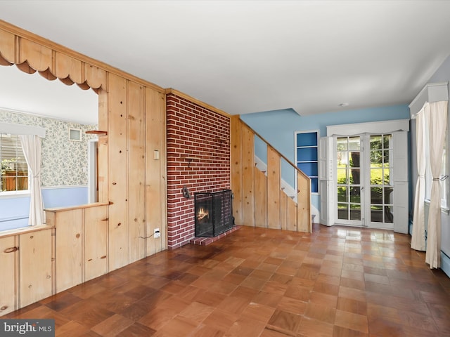 1229 7 Oaks Rd, Halethorpe, MD 21227 - unfurnished living room with stairs, a fireplace, and wooden walls