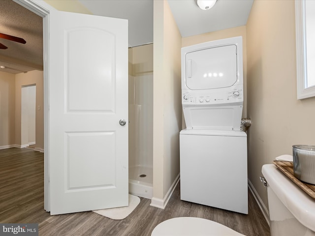 111 S Buchannan St, Ranson, WV 25438 - laundry area featuring stacked washer / dryer, wood finished floors, baseboards, and a ceiling fan
