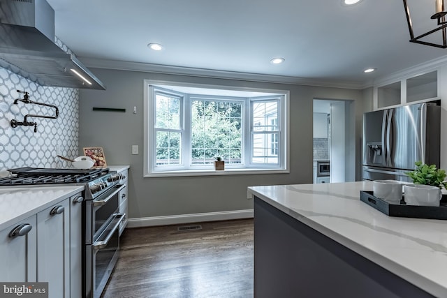 5632 Glenwood Dr, Alexandria, VA 22310 - kitchen with appliances with stainless steel finishes, wall chimney exhaust hood, ornamental molding, dark wood-type flooring, and light stone counters