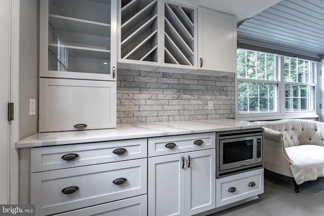 5632 Glenwood Dr, Alexandria, VA 22310 - kitchen with stainless steel microwave, white cabinetry, and backsplash
