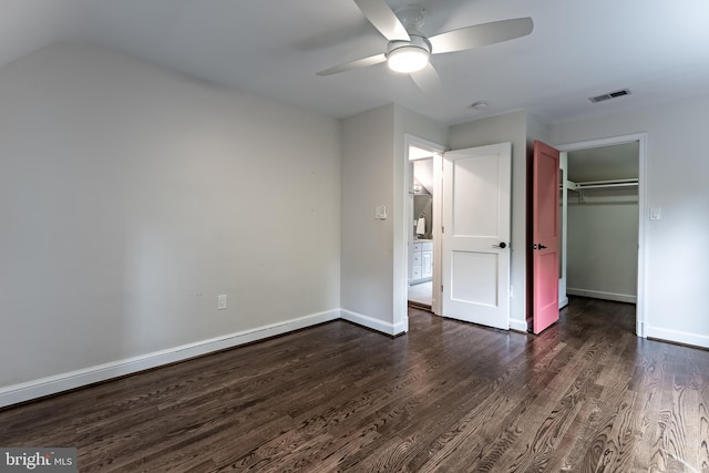 5632 Glenwood Dr, Alexandria, VA 22310 - unfurnished bedroom featuring dark wood-style flooring, a ceiling fan, a closet, and a walk in closet